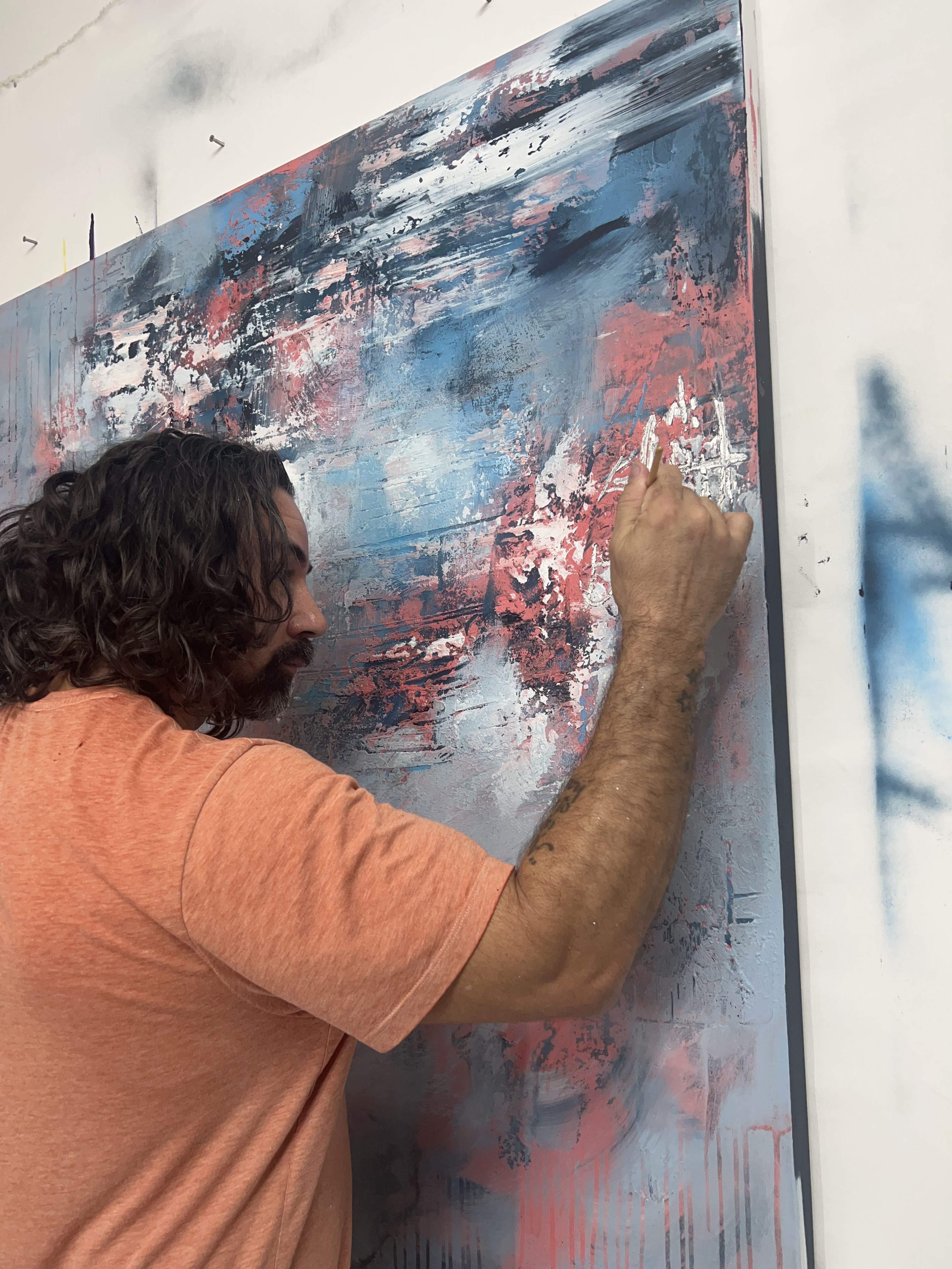 Person painting a large abstract artwork on a canvas.